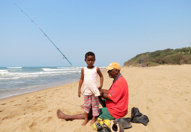 Fisherman and his granddaughter on the beach